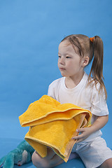 Image showing Small girl is keeping yellow towel isolated