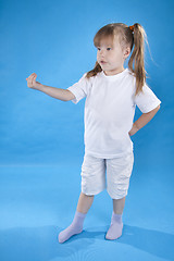 Image showing Small serious girl is posing isolated on blue