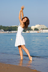 Image showing Young beautiful girl in a white dress on the beach