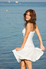 Image showing Young beautiful woman in a white dress against a background of t