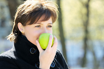 Image showing Cute woman in park with apple