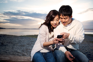 Image showing Asian couple texting