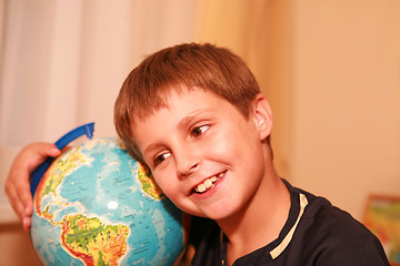 Image showing boy embracing globe of world