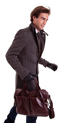 Image showing Portrait of a young man with a handbag, hasty, in autumn/winter clothes