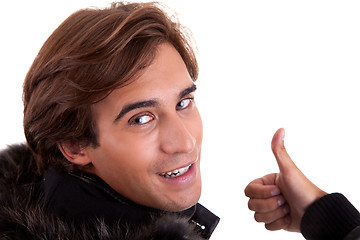 Image showing Portrait from back of a young man with thumb up, in autumn/winter clothes