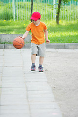 Image showing Little boy dribbling basketball