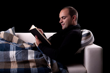 Image showing man lying on the sofa reading a book