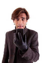 Image showing Portrait of a young unhappy businessman looking to the phone, in autumn/winter clothes