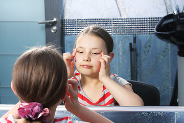 Image showing Girl narrowing eyes at mirror