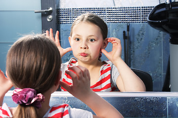 Image showing Girl grimacing at mirror
