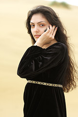 Image showing Young woman in desert calling by cellphone