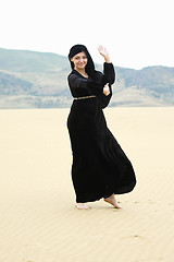 Image showing Young smiling woman dancing in desert