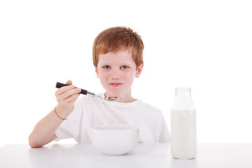 Image showing cute boy taking breakfast, isolated on white