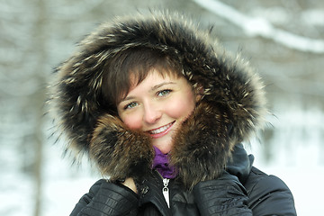 Image showing Smiling woman in frosty day hands at hood