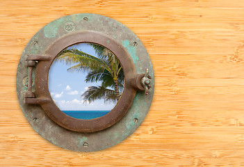 Image showing Antique Porthole with Tropical Beach View on Bamboo Wall