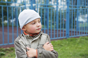 Image showing Little boy outdoors arms folded