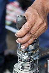 Image showing Mechanic repairing a gearbox