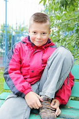 Image showing Smiling boy buckling shoes