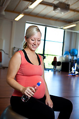 Image showing Pregnant woman relaxing with water bottle in hand.