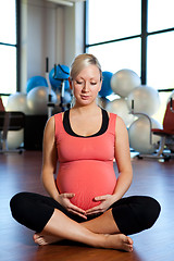 Image showing Pregnant woman holding her belly and relaxing.