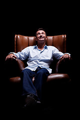 Image showing Man smiling and looking up seated on a chair