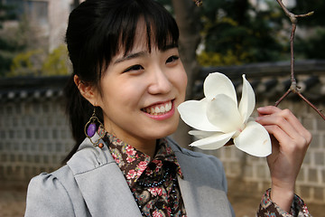 Image showing Pretty Korean woman holding a flower in spring