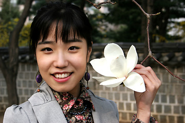 Image showing Pretty Korean woman holding a flower