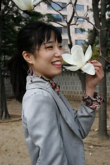 Image showing Pretty Korean woman holding a flower