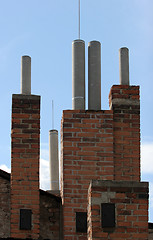 Image showing Many of brick chimneys on the top of the house