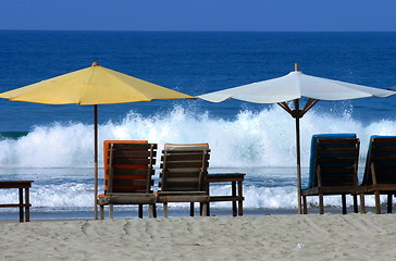 Image showing colorful beach umbrellas with seats