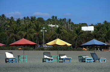 Image showing colorful beach umbrellas with seats