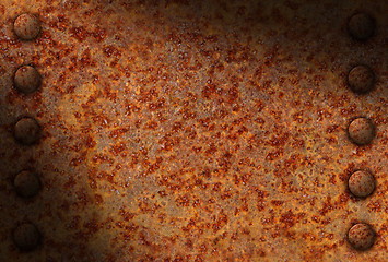 Image showing Rusted metal surface with rivets diagonally lit