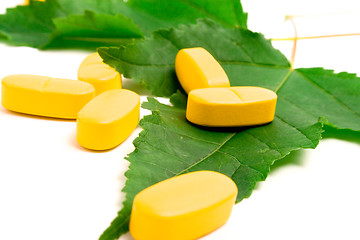 Image showing vitamin pills over green leaves