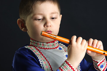 Image showing Little kid looking at wooden flute