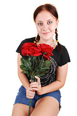 Image showing Pretty girl sitting on a chair with roses.