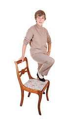 Image showing Lady standing on chair.