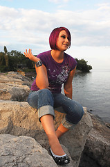 Image showing Girl sitting on lakeshore.