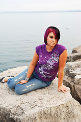 Image showing Girl sitting on lakeshore.