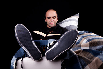 Image showing man lying on the sofa reading a book