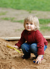 Image showing child plays with sand