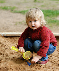 Image showing child plays with sand