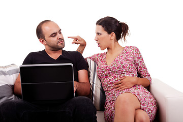 Image showing couple sitting on the couch, he playing computer and she argues with him