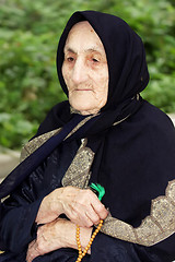 Image showing Elderly woman with beads looking sideways