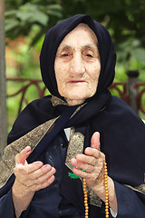 Image showing Elderly woman with beads gesticulating