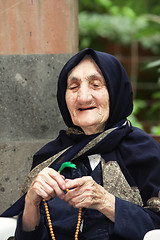 Image showing Smiling elderly woman with beads