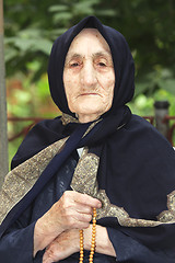 Image showing Elderly woman with beads