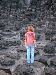 Image showing Woman standing on volcanic rock