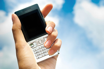 Image showing Mobile phone in hand over blue sky background.
