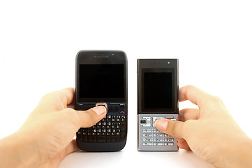 Image showing Two mobile phones in hands over white