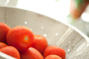 Image showing Fresh, Vibrant Roma Tomatoes in Colander with Water Drops